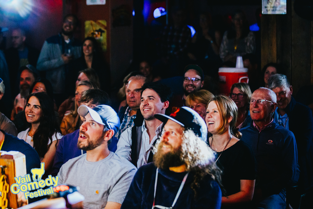 Audience members at a sold-out standing room only comedy show laugh and smile during the 2022 Vail Comedy Festival